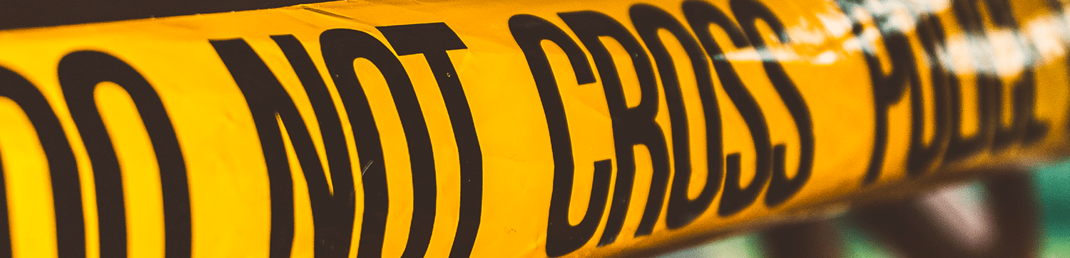 image a piece of yellow crime tape that states DO NOT CROSS