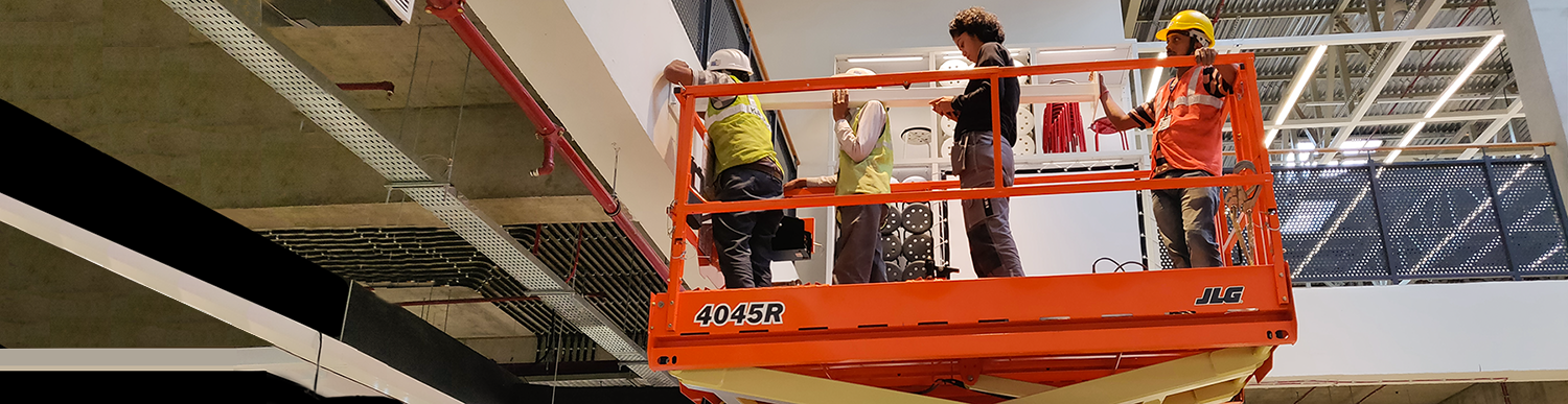 image of 4 people on a lift 3 of them replacing duct work and one analyzing them