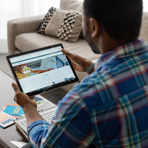 image of man sitting with a tablet in his hands watching a video