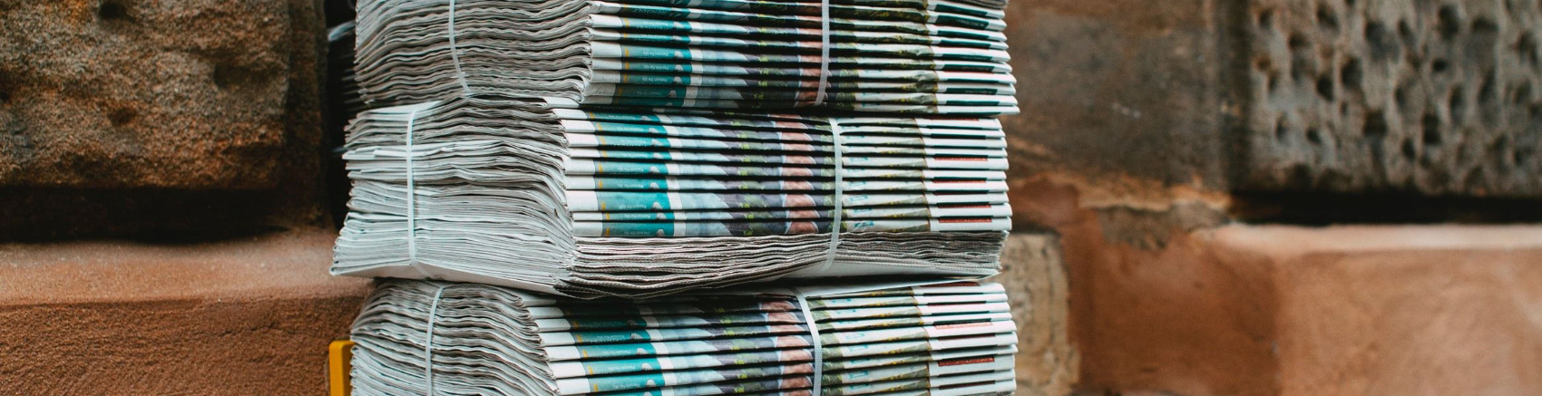 stack of newspapers on a doorstep